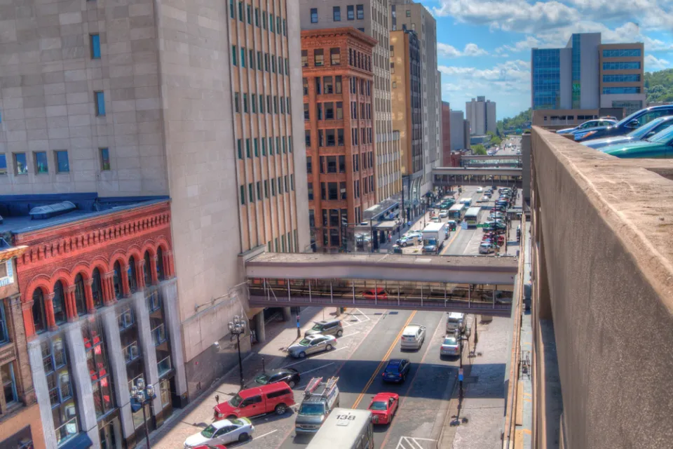 A busy street in Duluth, full of cars and buses.